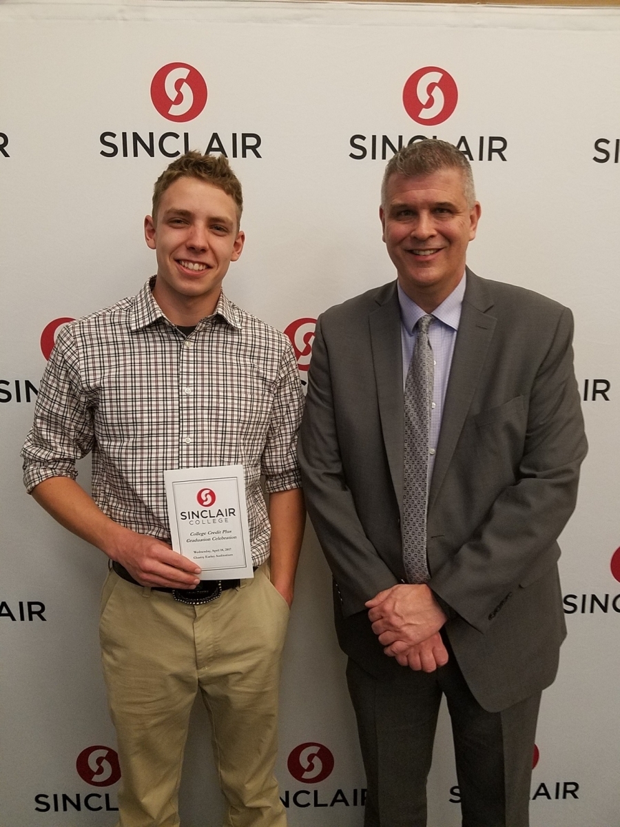 two men one of which is holding a certificate